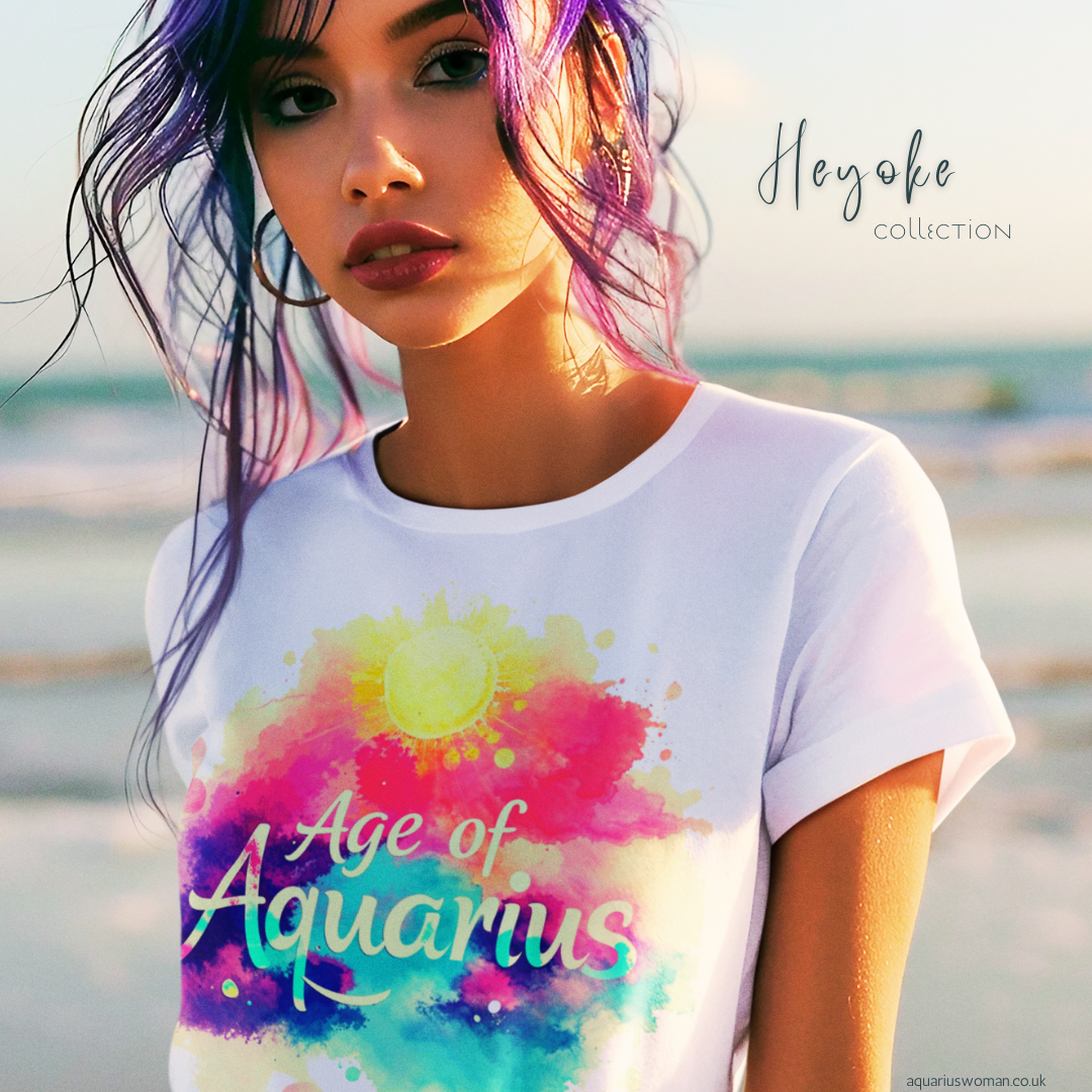 A woman wearing the 'Age of Aquarius' t-shirt from the Heyoke Collection by Aquarius Woman. Featuring a vibrant watercolour sunburst design, this piece symbolises enlightenment, individuality, and the awakening of higher consciousness.