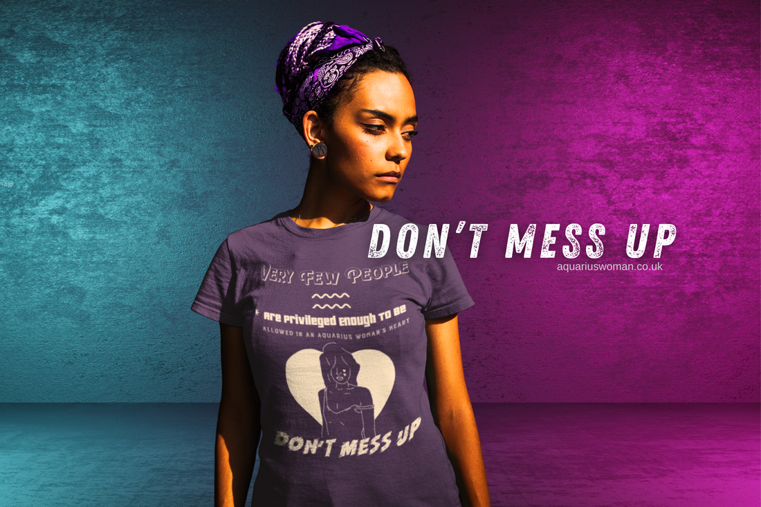 A strong, confident woman wearing a "Don't Mess Up" t-shirt stands against a bold purple and teal background. The design emphasizes exclusivity, resilience, and the privilege of being in an Aquarius Woman’s heart.